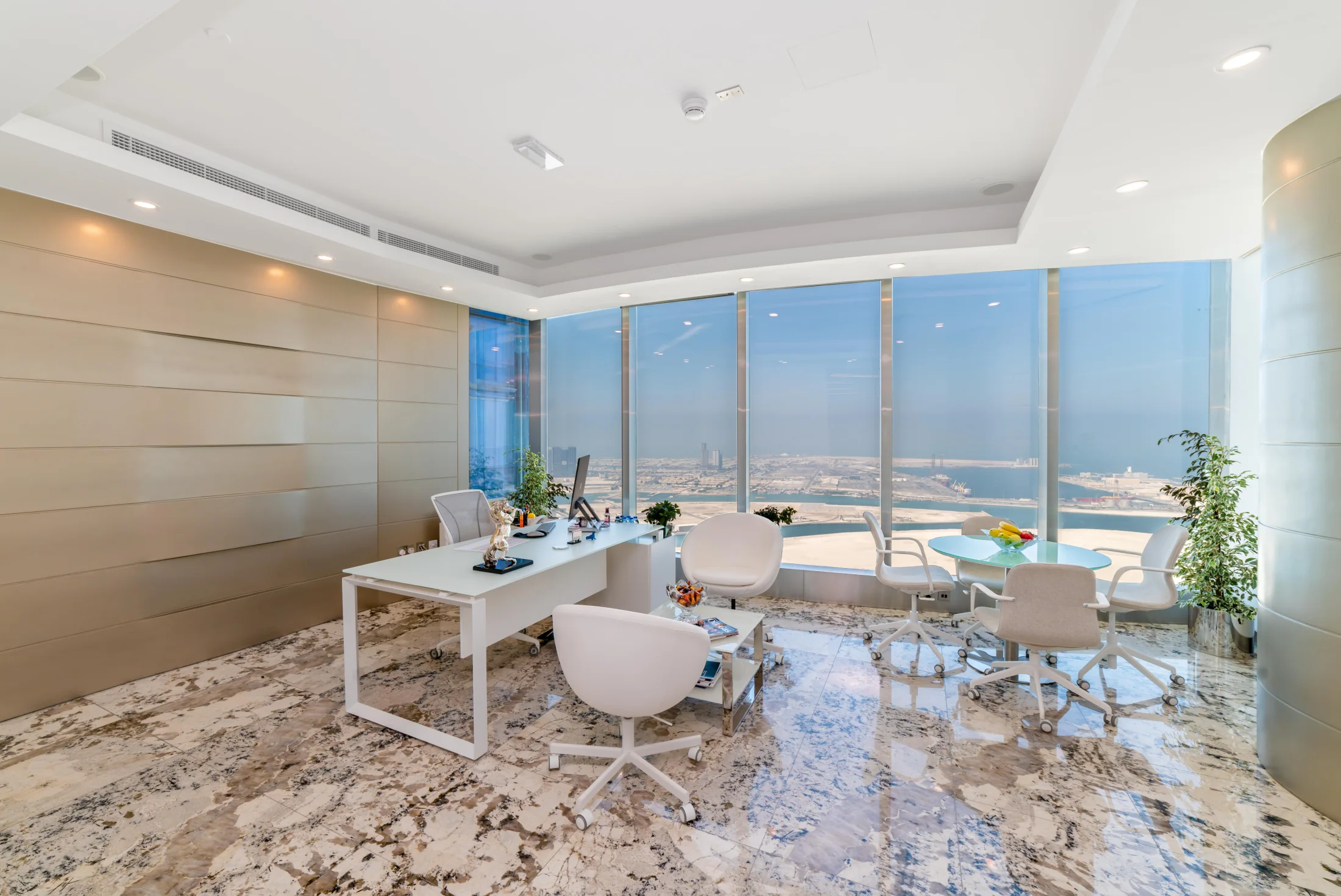 After view of the completed Addax Tower corporate office with desks, seating, and Abu Dhabi views.